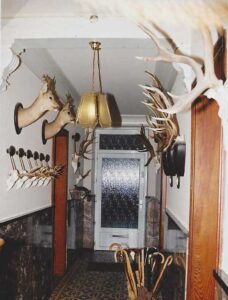 Couloir décoré de trophées de chasse et porte vitrée