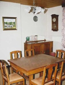 Salle à manger avec table en bois et horloge murale