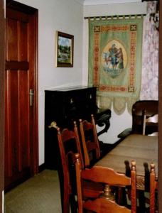 Salle à manger avec bannière brodée et chaises en bois